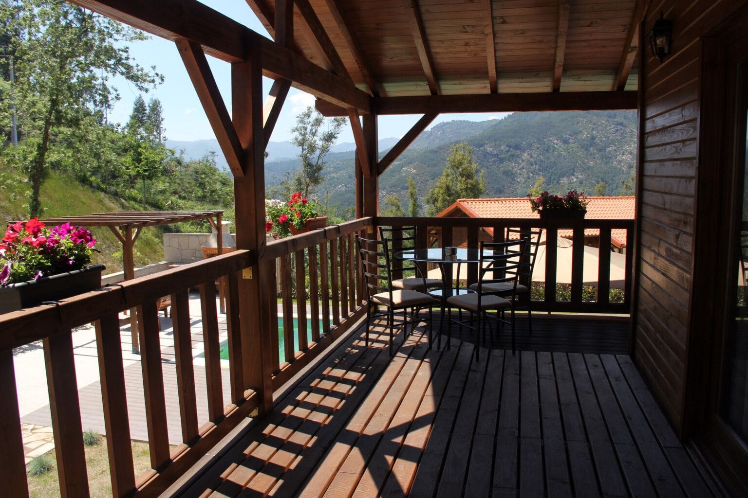 Alpendre de madeira com vista para a piscina e para a serra