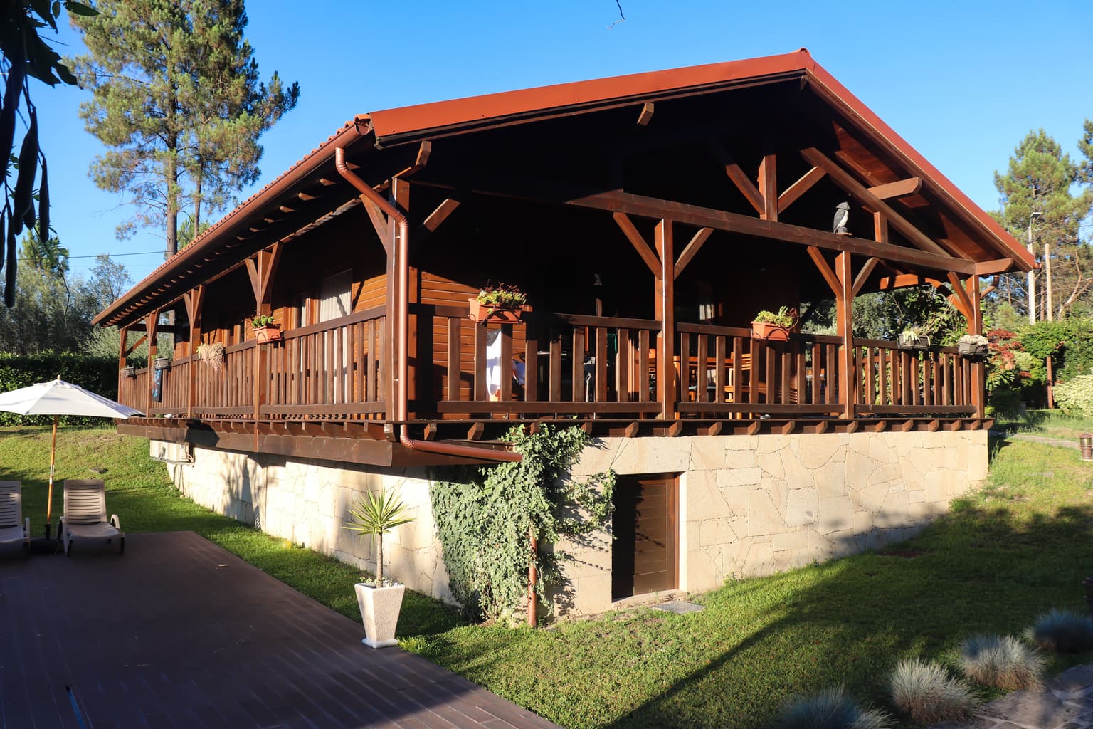 Casa do Sobreiro: chalé de madeira com alpendre corrido e relvado